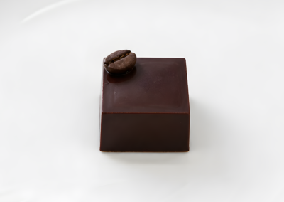 square dark chocolates, each topped with a single roasted coffee bean